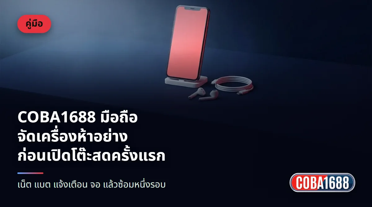 โทรศัพท์มือถือตั้งบนขาตั้งเล็ก หน้าจอสว่างสีแดง ข้างกันมีหูฟังและสายชาร์จบนโต๊ะสีน้ำเงินเข้ม